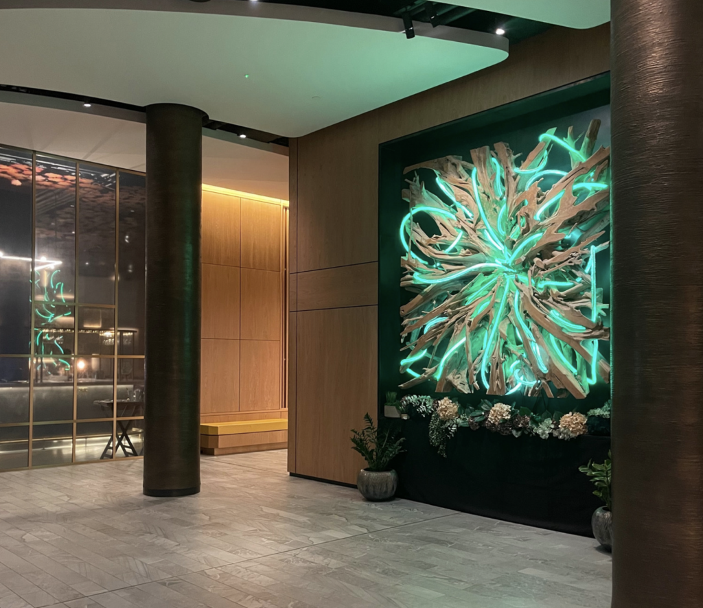 A neon sculpture hangs the wall of a lobby